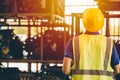 Male engineer worker back view looking at shelf in heavy industry factory metal work