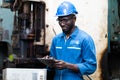 Male Engineer Working on digital tablet in Factory. black male engineer checking Quality control the condition of the machine