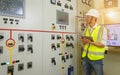 A male engineer working in an electrical control room in a heavy factory. Professional industrial engineer working in substation. Royalty Free Stock Photo