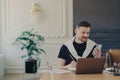 Male entrepreneur studying online, using smartphone while working at his workplace in modern office Royalty Free Stock Photo