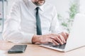 Male entrepreneur using laptop in office, closeup of hands typing the portable computer keyboard Royalty Free Stock Photo