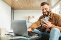 Male Entrepreneur Using Smartphone And Laptop Working Online At Home Royalty Free Stock Photo