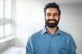 Male entrepreneurship. Closeup portrait of indian bearded businessman smiling at camera in office, copy space Royalty Free Stock Photo