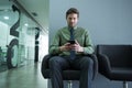 Male executive using mobile phone in waiting area Royalty Free Stock Photo