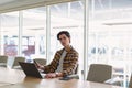 Male executive using mobile phone while working on laptop in the conference room at office Royalty Free Stock Photo