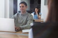 Male executive working on laptop while looking at camera Royalty Free Stock Photo