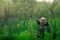 Male explorer makes observations in the wild with a spotting scope standing among the tall grass Royalty Free Stock Photo