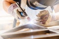 Male in face mask welds with argon-arc welding