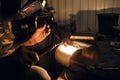 Male in face mask welds with argon welding. Industrial welder worker welding using argon machine, close up. Man working