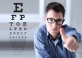 male face with spectacles on eyesight test chart background, showing like hand, eye examination ophthalmology concept Royalty Free Stock Photo