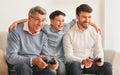 Male Family Of Three Playing Videogames Sitting On Couch Indoor Royalty Free Stock Photo