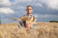 Male farmer or baker with baguettes in rye, wheat field