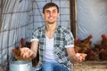 Male farmer picking fresh eggs in coop Royalty Free Stock Photo