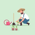 Male farmer planting young seedlings plants flowers and vegetables man working in garden agricultural worker in uniform Royalty Free Stock Photo