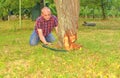 Male farmer sawing old tree. Middle aged man cutting fruit tree down. Mature man, gardener in summer