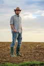 Male Farmer Standing on Fertile Agricultural Farm Land Soil Royalty Free Stock Photo