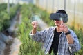 Male farmer with VR headset in rosemary field. Innovative technologies and futuristic agriculture concept
