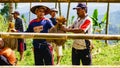 Male farmer working together passing dried harvested rice