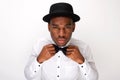 Male fashion model adjusting his bowtie by white background Royalty Free Stock Photo