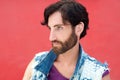 Male fashion model with beard posing on red background