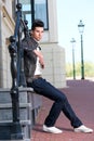 Male fashion model in leather jacket sitting outdoors Royalty Free Stock Photo