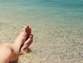 Male feet on a beach against the sea in a summer sunny day Royalty Free Stock Photo