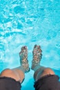 Male feet dipping in swimming pool Royalty Free Stock Photo