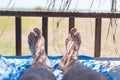 Male feet on lounge in bungalow sea view Royalty Free Stock Photo