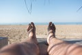 Male feet on lounge in bungalow sea view Royalty Free Stock Photo