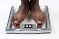 Male feet standing on electronic scales for weight control on white background. The concept of slimming and weight loss Royalty Free Stock Photo