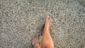 Male feet walking over sandy ocean beach and pebbles through calm clear sea water Royalty Free Stock Photo