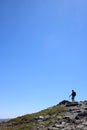 Male fellwalker on skyline on mountain footpath