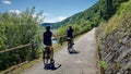 Senior couple cycling along the pretty pathway adjacent to the Rhine River near Koblenz, Germany.