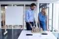 Male and female architect discussing over architectural model at table in a modern office Royalty Free Stock Photo