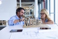 Male and female architect discussing over architectural model at table in a modern office Royalty Free Stock Photo