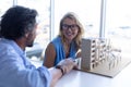 Male and female architect discussing over architectural model at table in a modern office Royalty Free Stock Photo