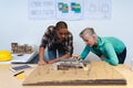 Male and female architects discussing over model structure of house at desk Royalty Free Stock Photo