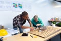 Male and female architects discussing over model structure of house at desk Royalty Free Stock Photo