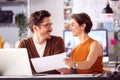 Male And Female Architects In Office Working At Desk On Laptop And Looking At Plans Royalty Free Stock Photo