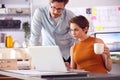 Male And Female Architects In Office Working At Desk On Laptop Together With Hot Drinks Royalty Free Stock Photo