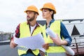 male and female architects working with blueprints