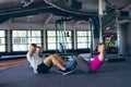 Male and female athletic exercising together in fitness center