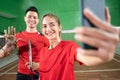 Male and female badminton players smiling while taking a selfie