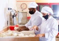 Male and female baker in protective mask working together in bakery Royalty Free Stock Photo