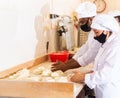 Male and female baker in protective mask working together in bakery Royalty Free Stock Photo