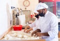 Male and female baker in protective mask working together in bakery Royalty Free Stock Photo