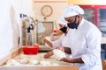 Male and female baker in protective mask working together in bakery Royalty Free Stock Photo