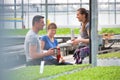 Male and female botanists enjoying coffee break in greenhouse Royalty Free Stock Photo