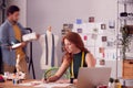 Male And Female Business Owners Working On Designs In Busy Fashion Studio Together Royalty Free Stock Photo