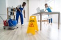 Male And Female Cleaners Cleaning Office Royalty Free Stock Photo